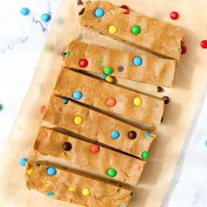 6 protein bars on a piece of parchment paper, topped with m&m candies.