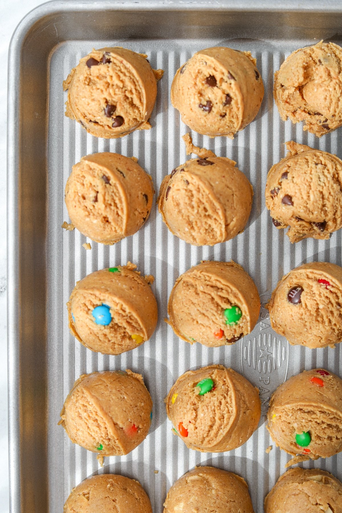 A baking sheet with scooped cookie dough.