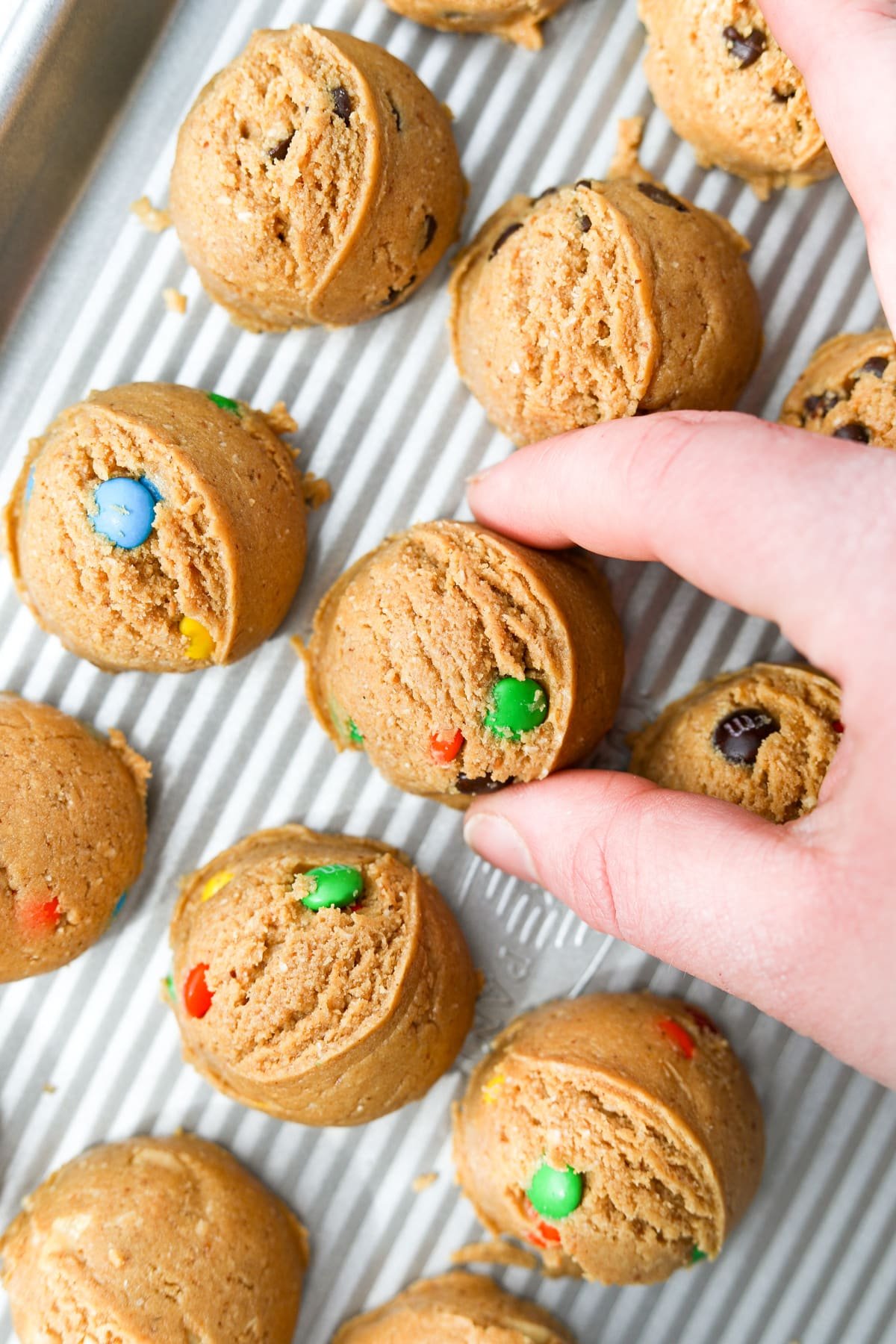 Placing a mound of cookie dough on a baking tray.