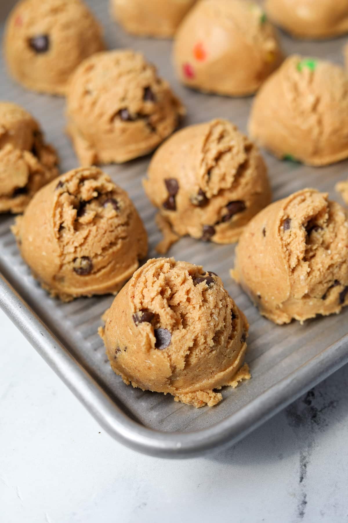 Scoops of cookie dough on a baking sheet.