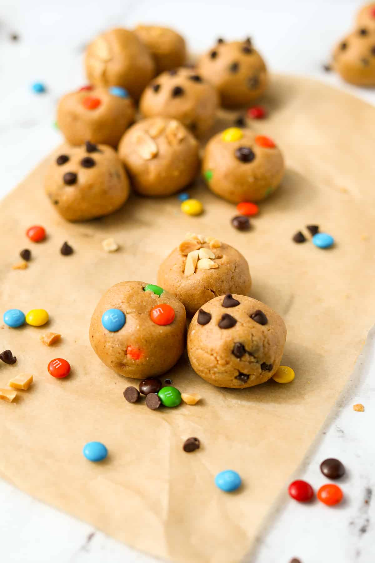 Three protein cookie dough balls in the center, with others on the sidelines.