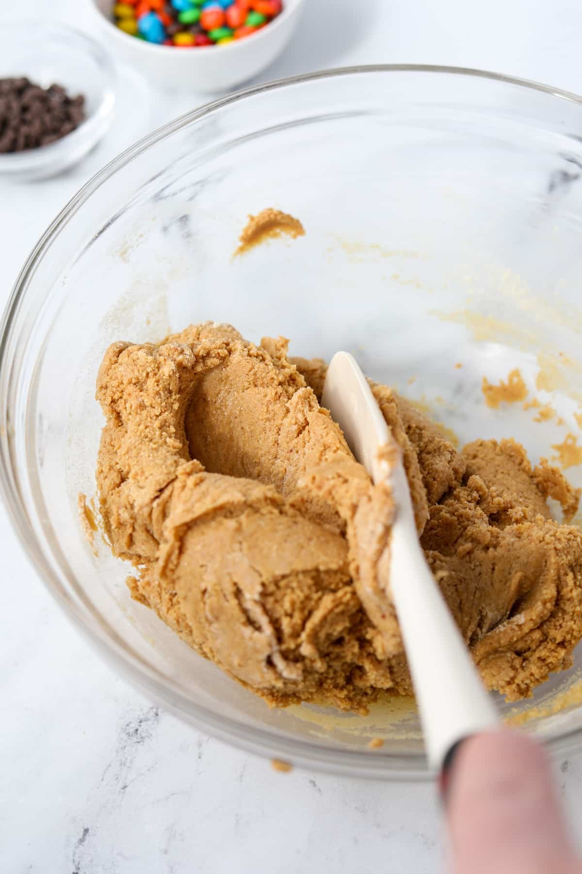 Mixing together a protein cookie dough in a bowl.