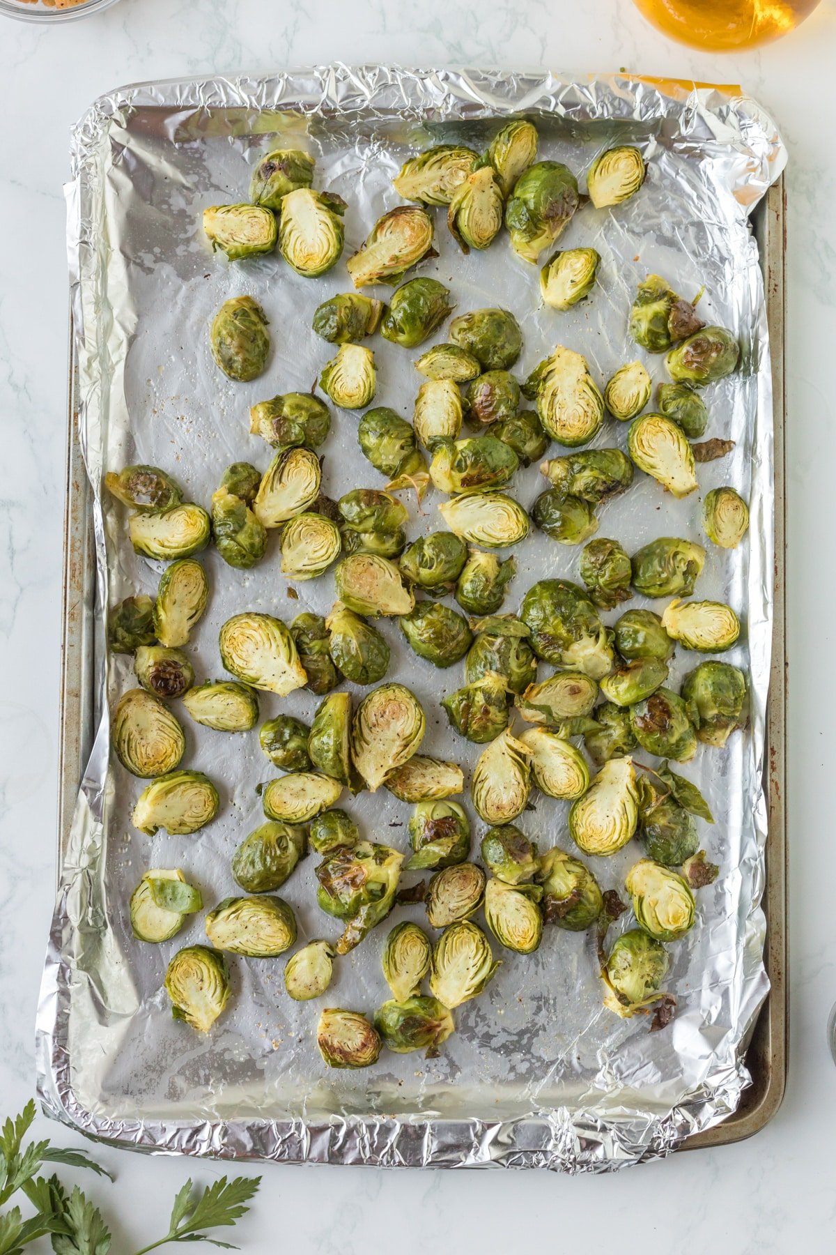 A foil-lined pan with roasted brussels sprouts.