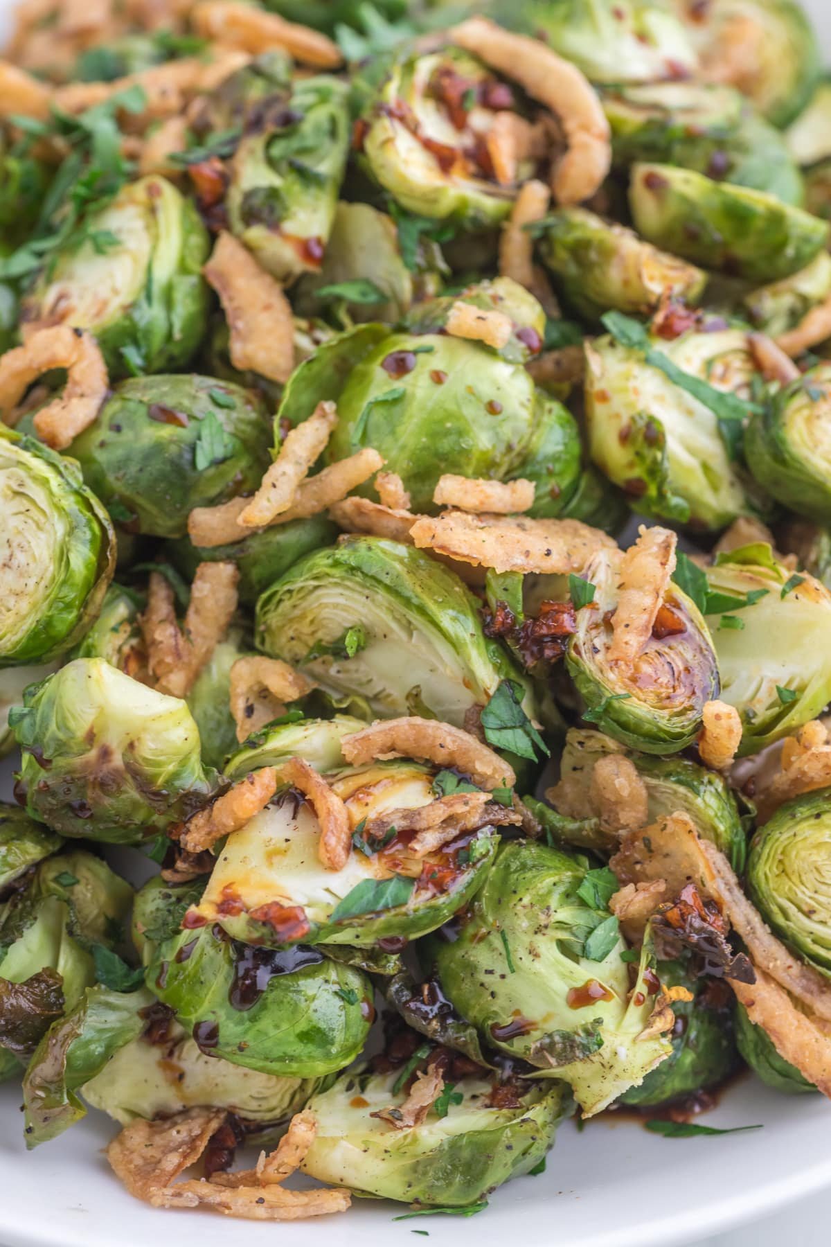 A close up of brussels sprouts that have been roasted and topped with crispy onions.