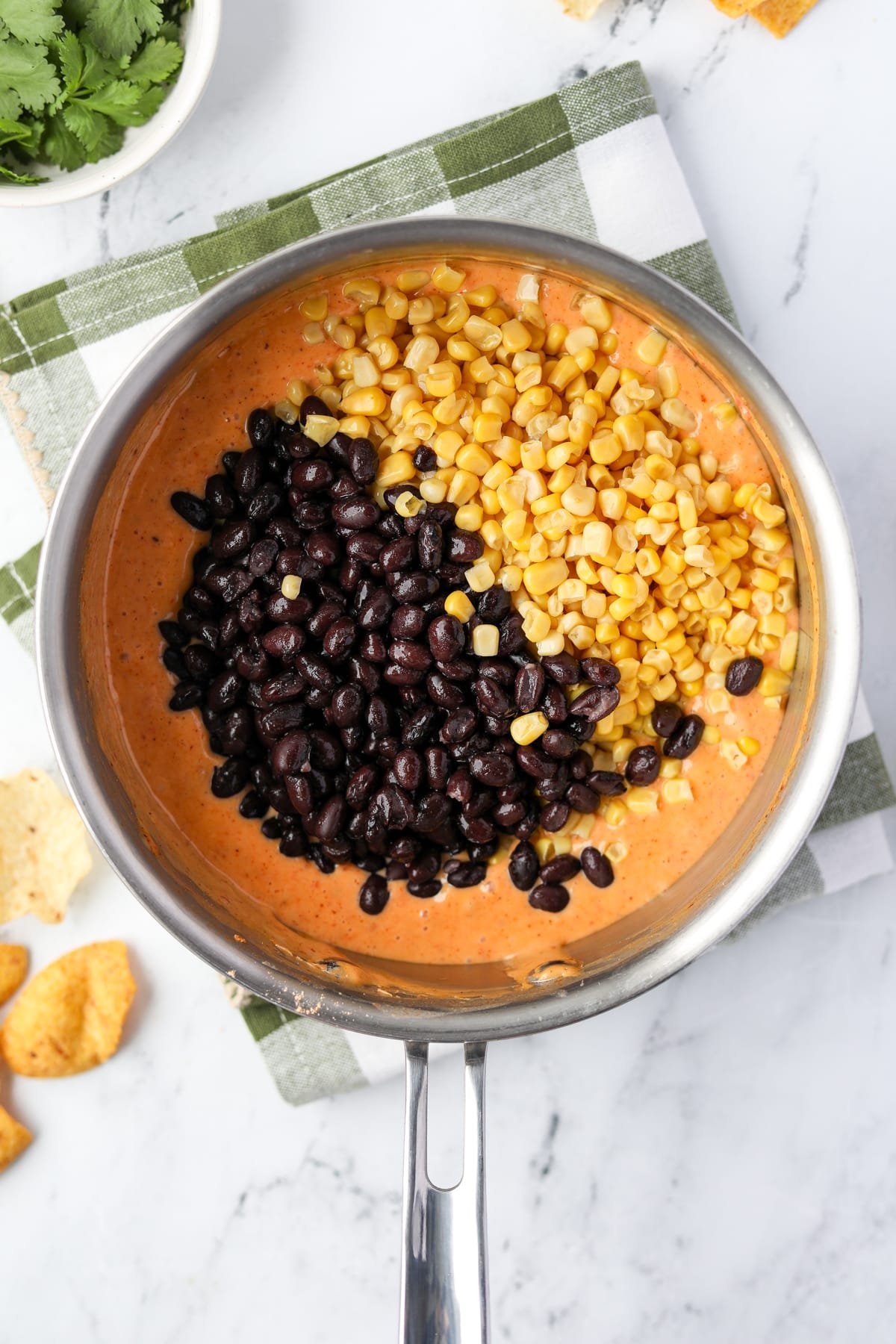Adding beans and corn to melted Rotel dip.
