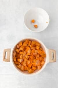 A pot filled with water and sweet potato cubes.