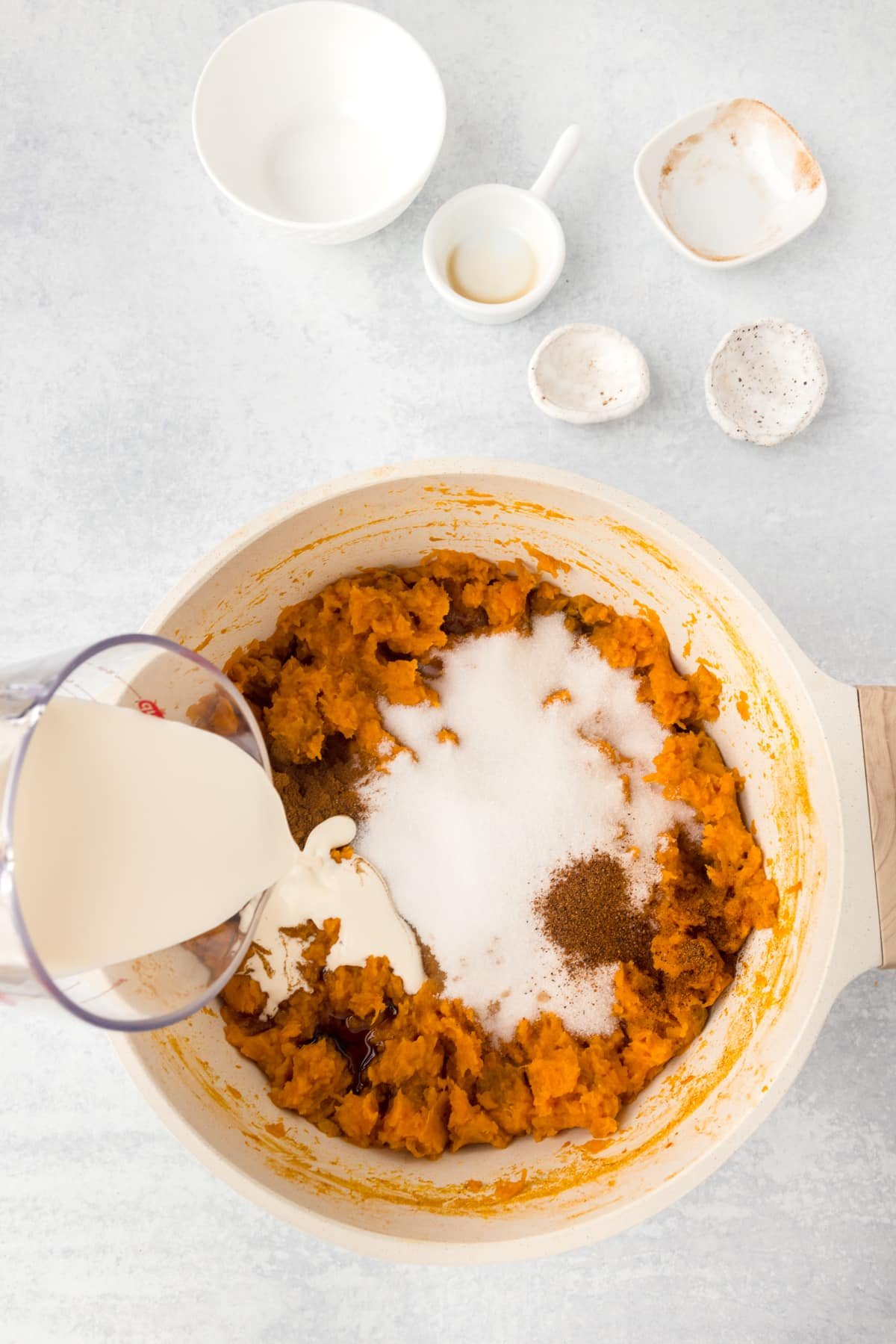 A pot of mashed sweet potatoes with sugar, cinnamon, and cream added.