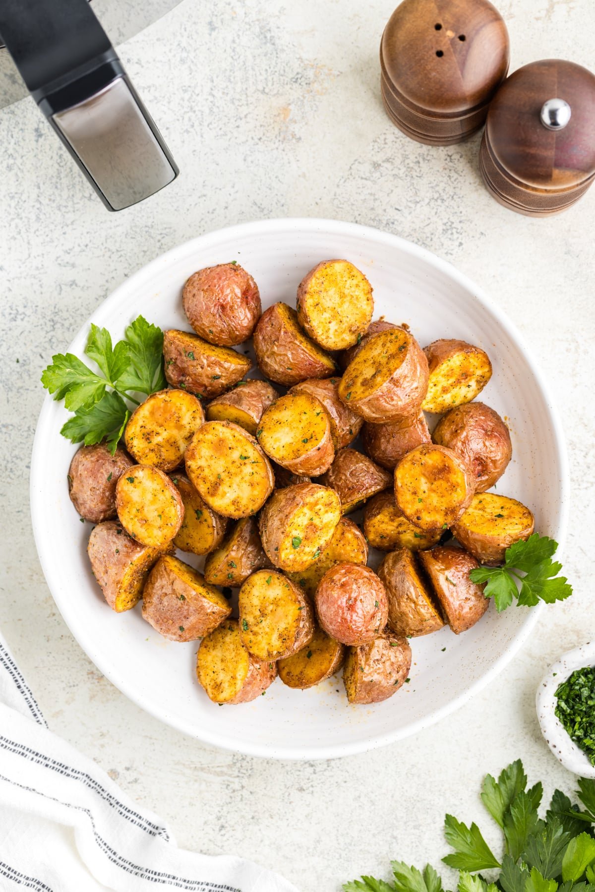 A white plate filled with roasted red baby potatoes.