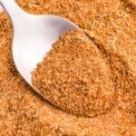 Spooning cajun seasoning from a homemade mix.