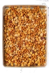 A baking sheet filled with baked snack mix.