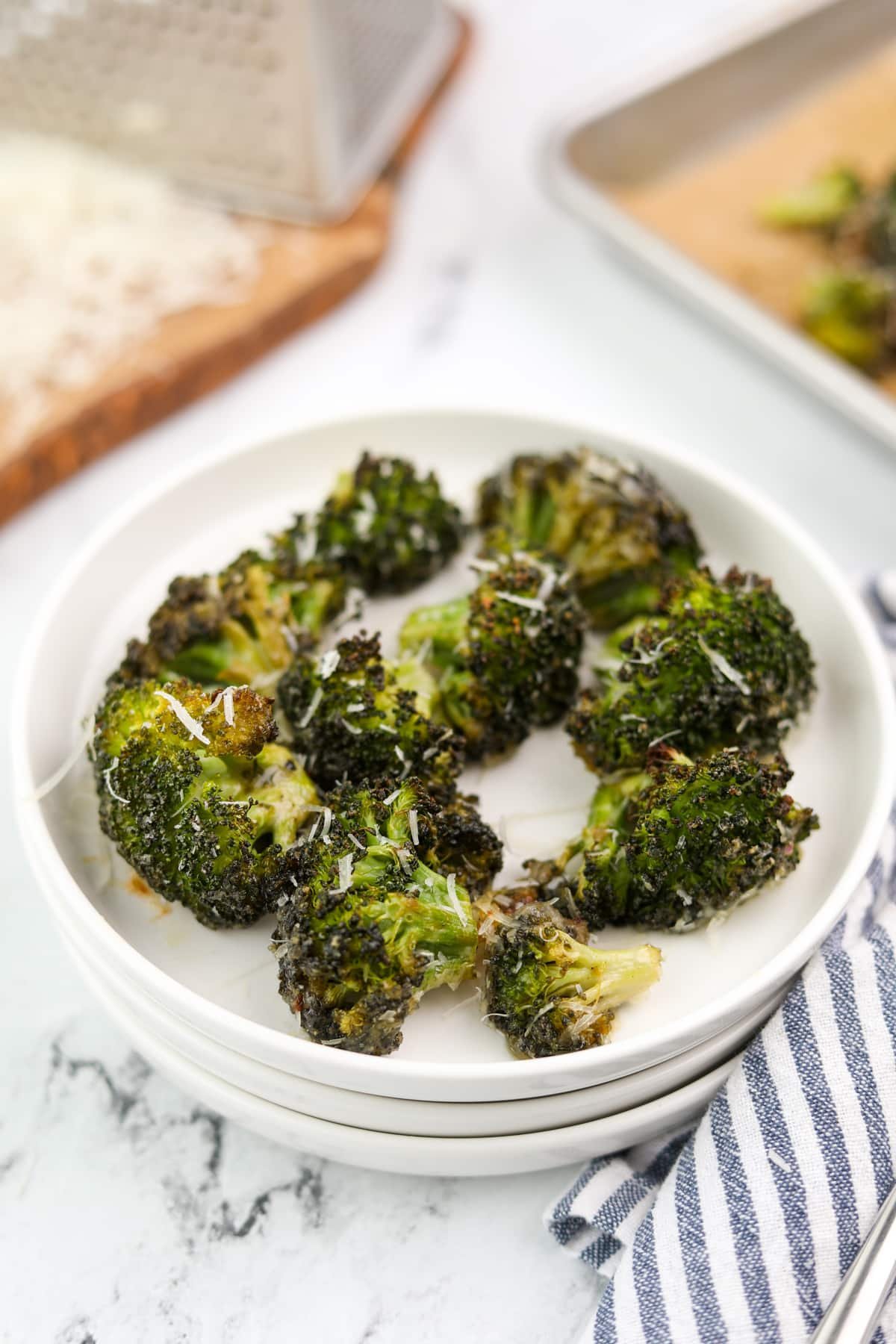 A small plate with a serving of roasted broccoli.