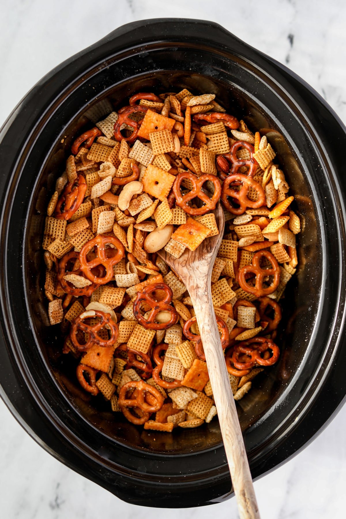 Stirring Chex Mix in a slow cooker.