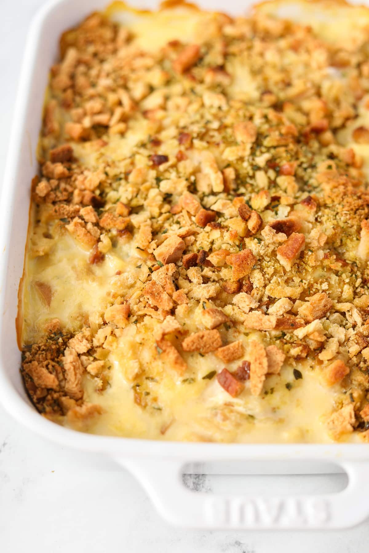 A close up of a baking dish filled with a stuffing-topped casserole.