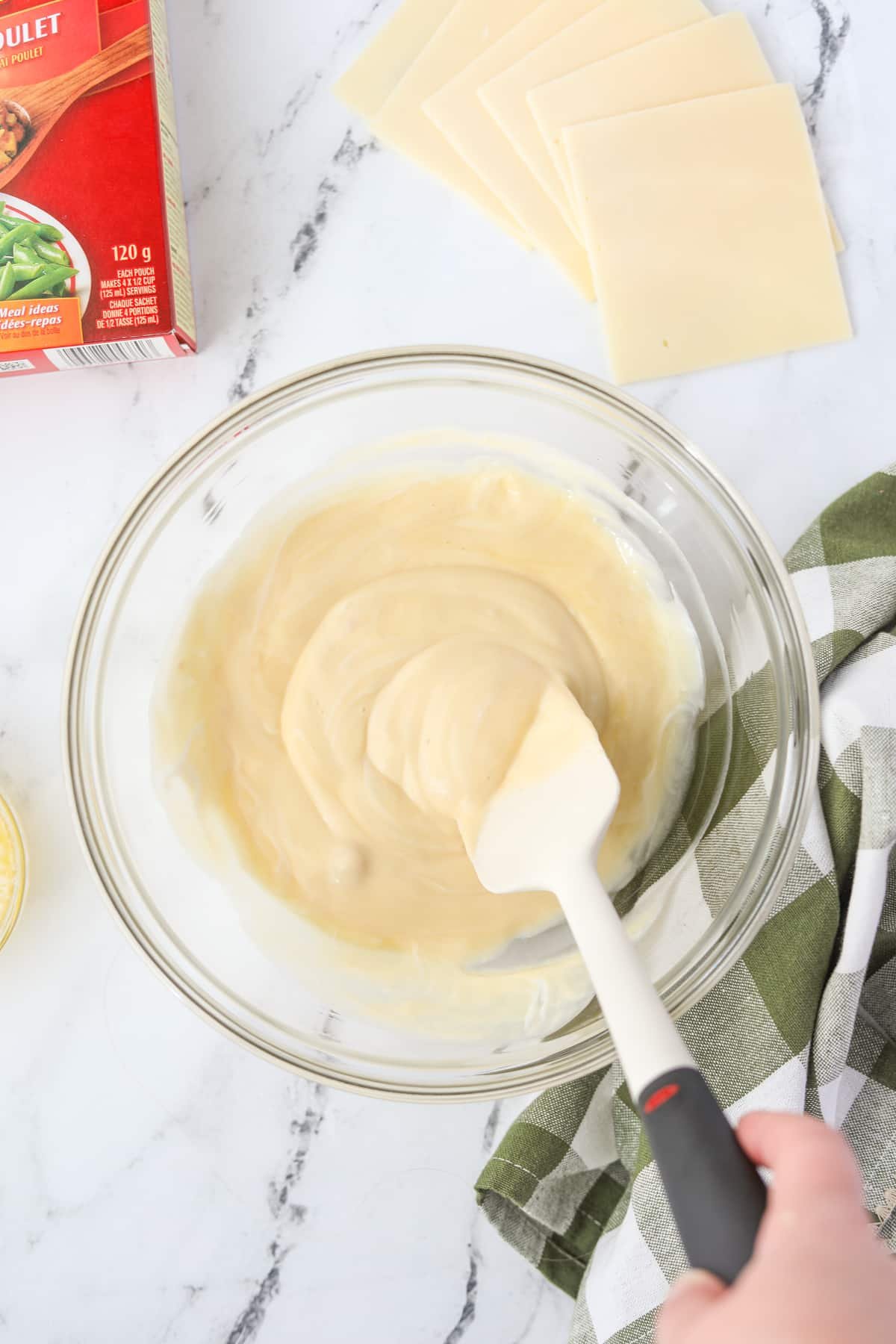 Stirring together soup and sour cream to make a sauce.