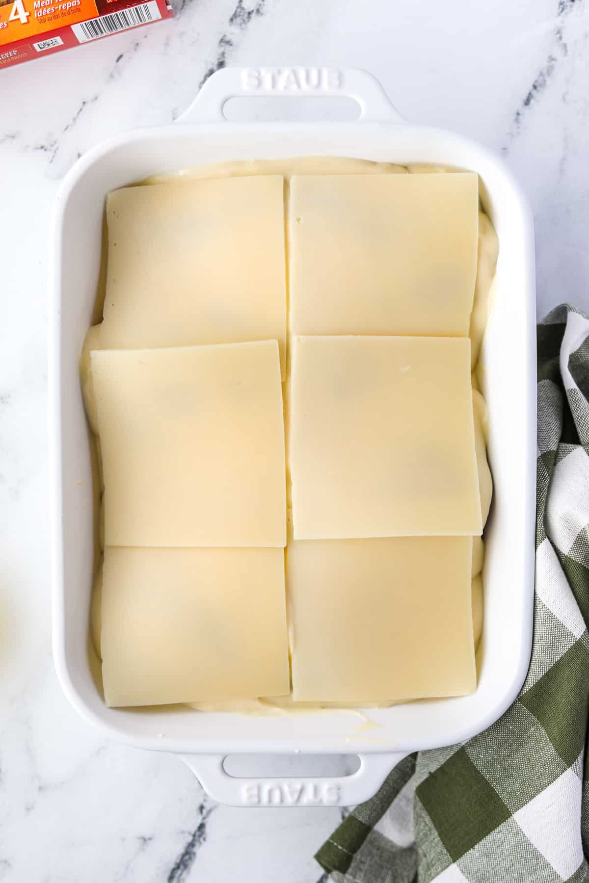 Topping a casserole with Swiss cheese slices.