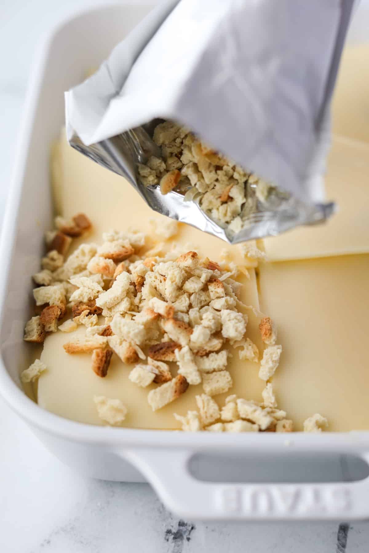 Sprinkling stuffing mix on top of a casserole.