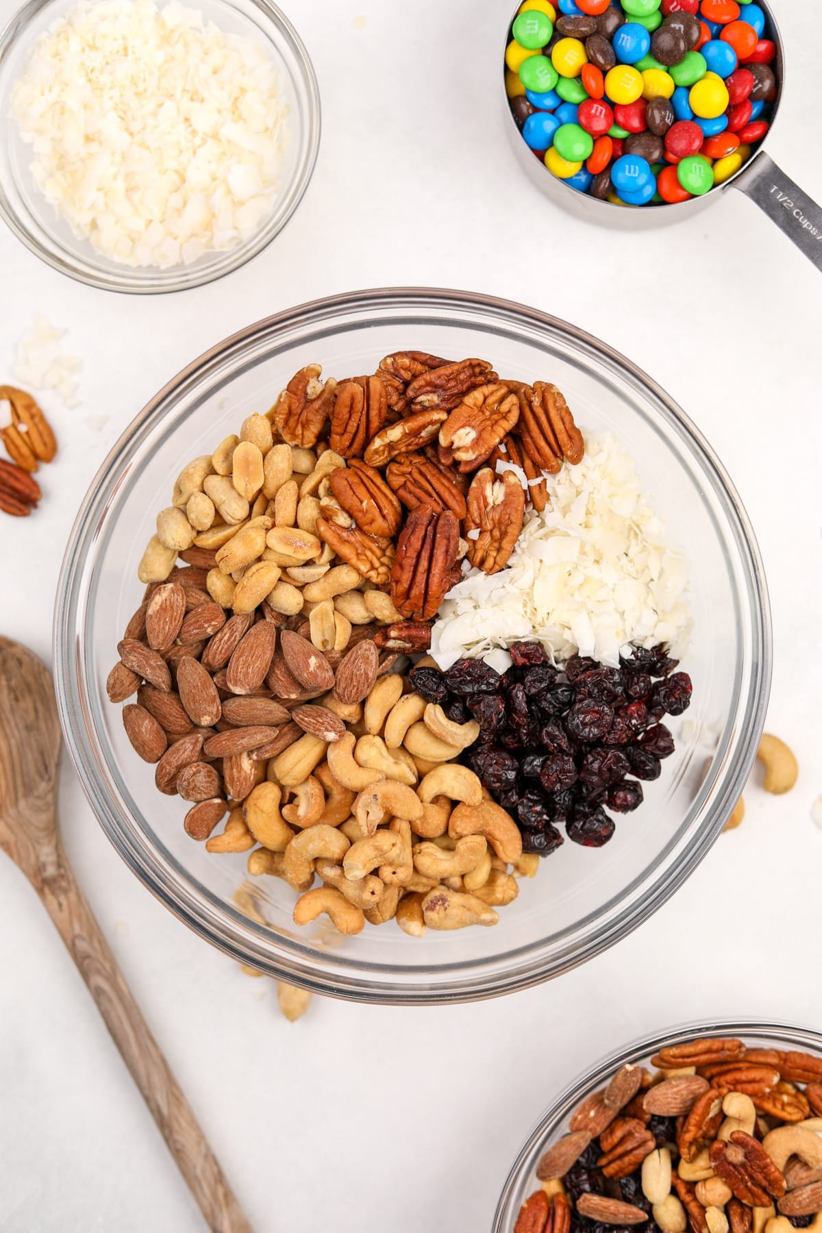 A bowl filled with different sections of nuts, coconut, and dried fruit.