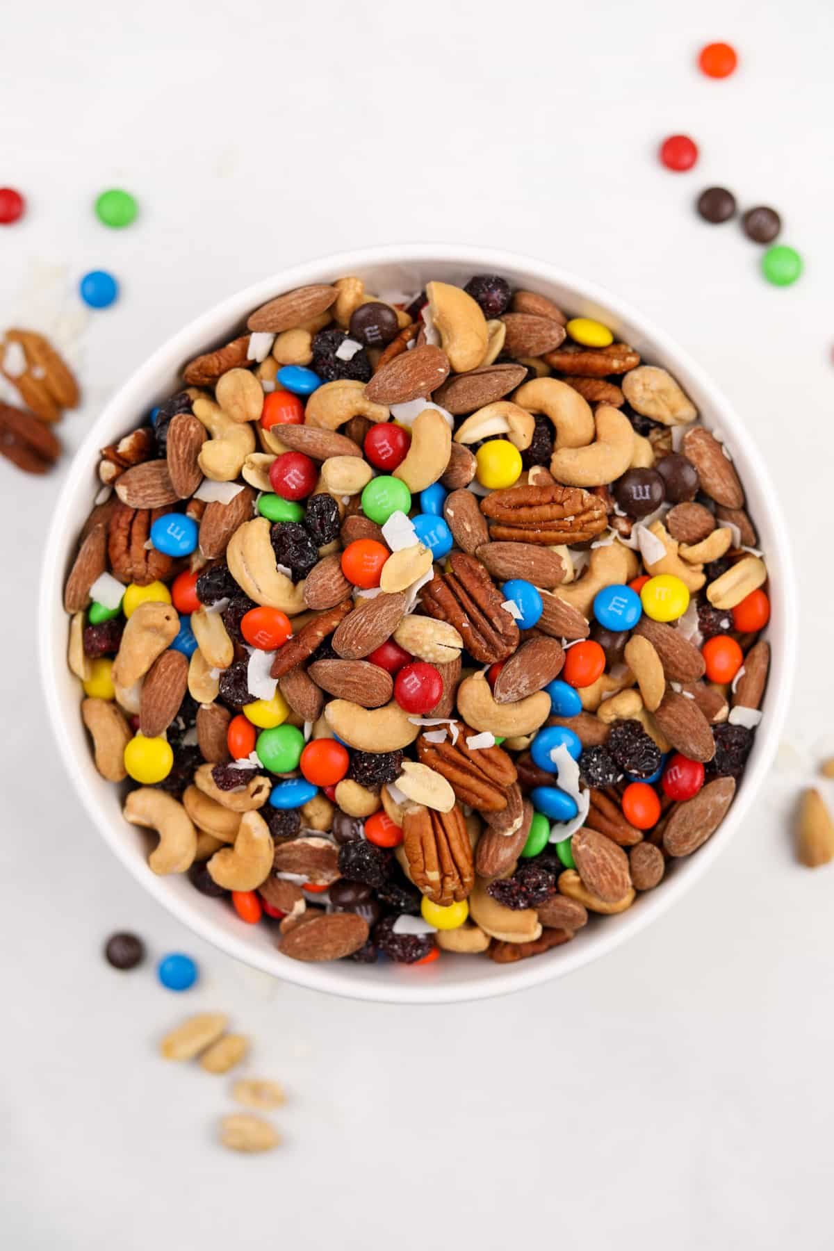 A large bowl of trail mix on a white surface.