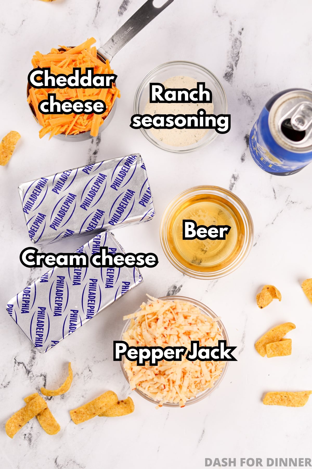 The ingredients needed to make beer dip, including cream cheese, beer, pepper jack cheese, cheddar cheese, and ranch seasoning.