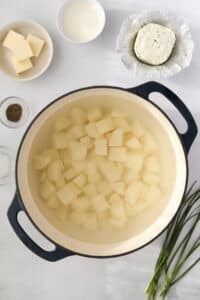 A dutch oven filled with cubed potatoes.