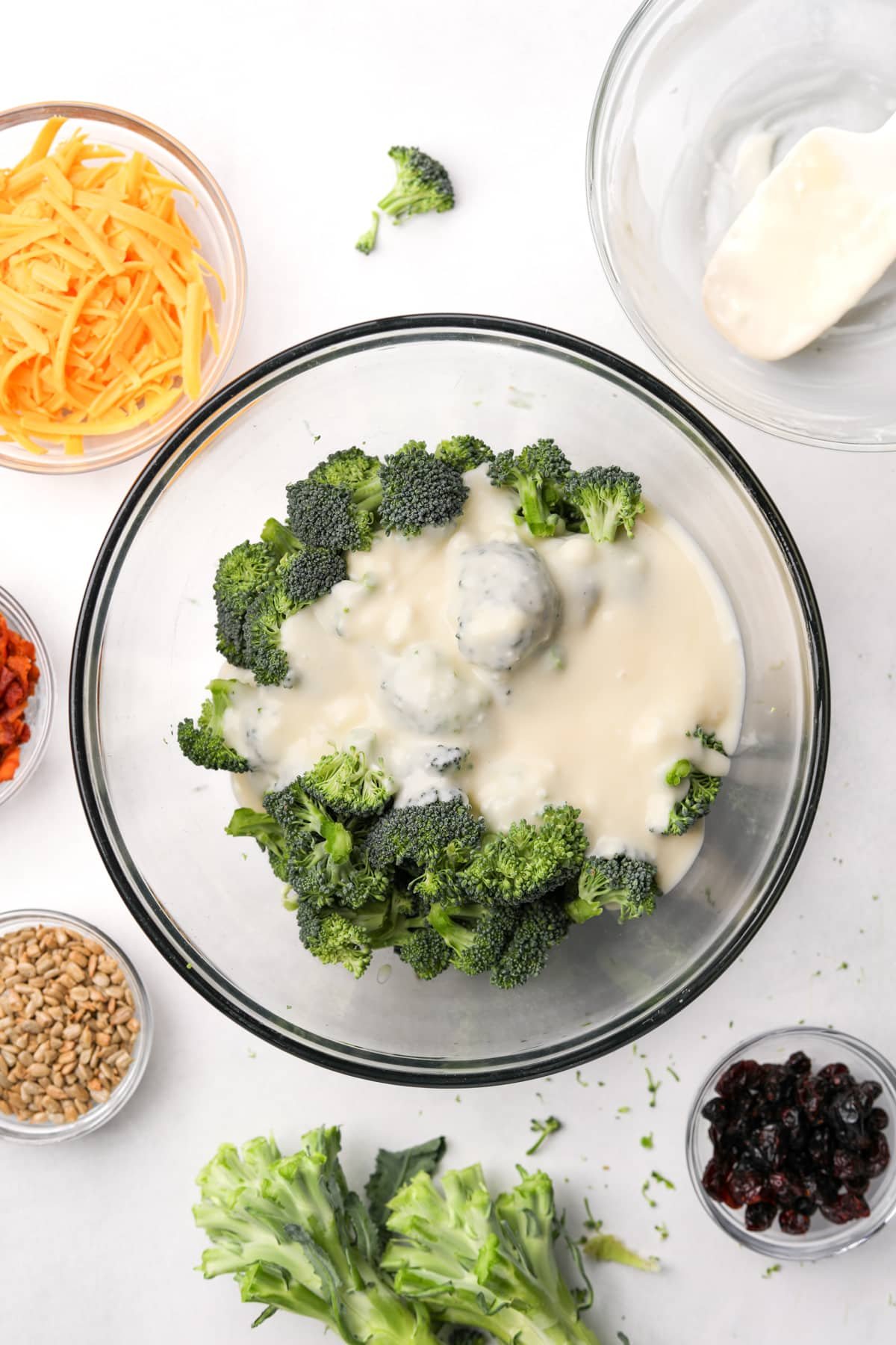 A bowl of broccoli with a creamy dressing poured on top.