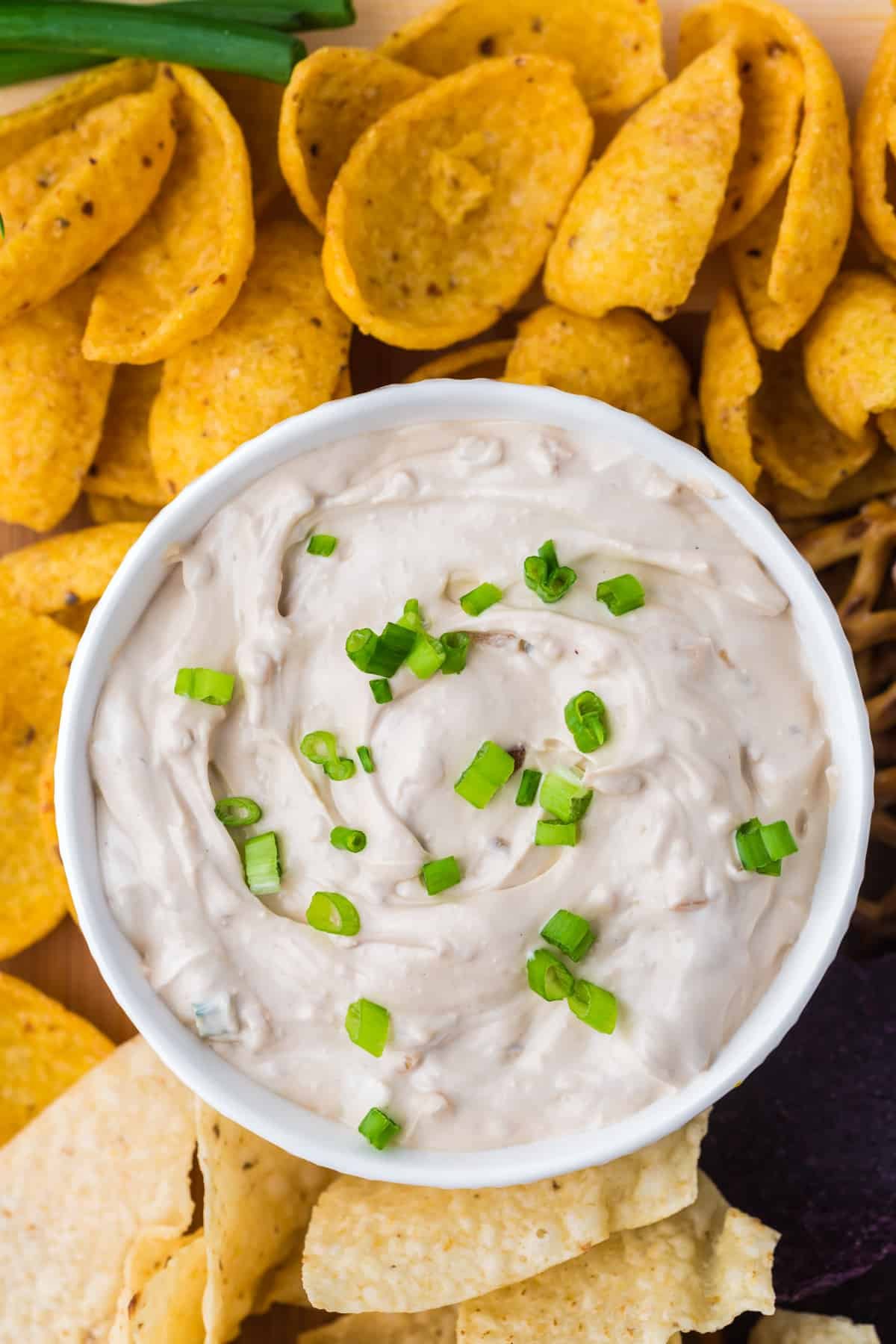 An overhead view of french onion dip garnished with green onions.