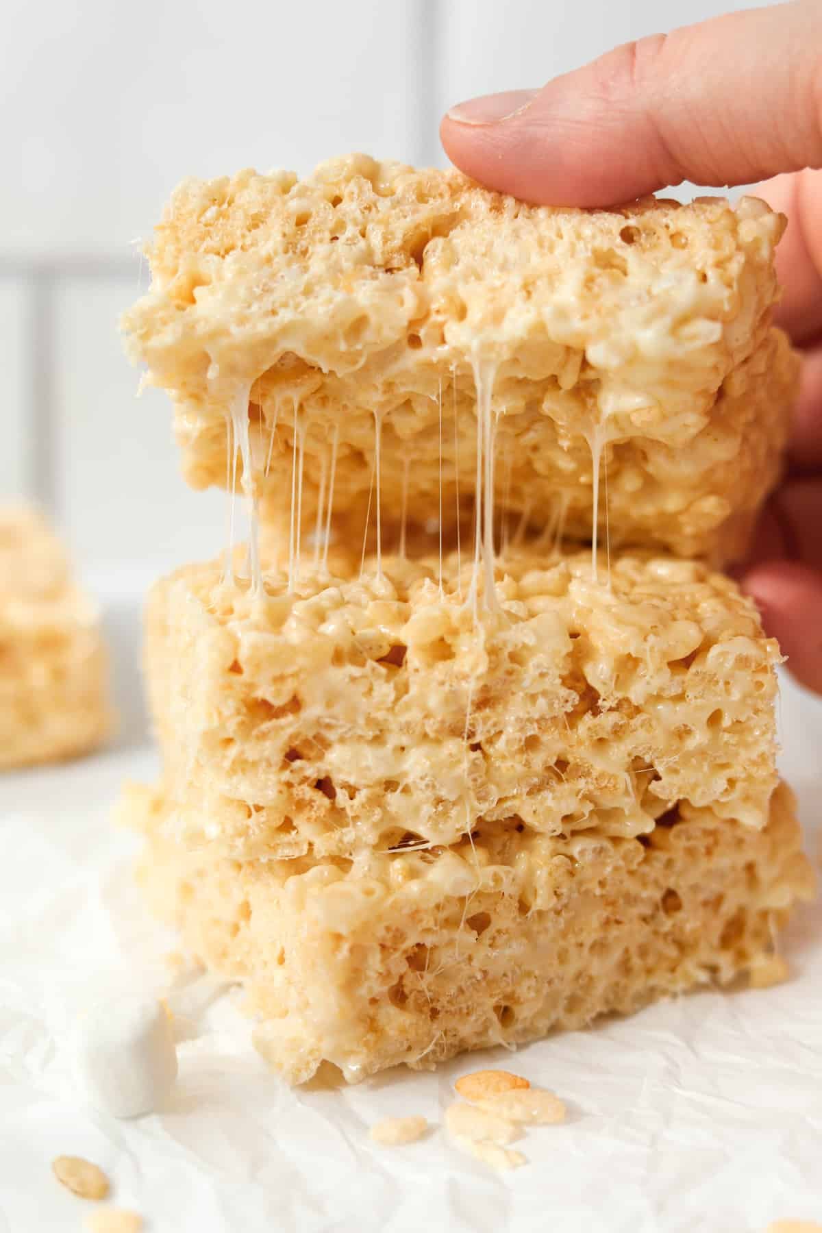 A stack of rice krispie treats being pulled apart, showing the gooey marshmallows.
