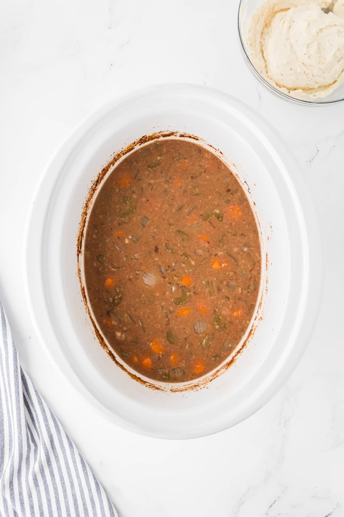 A slow cooker filled with cooked beef stew.