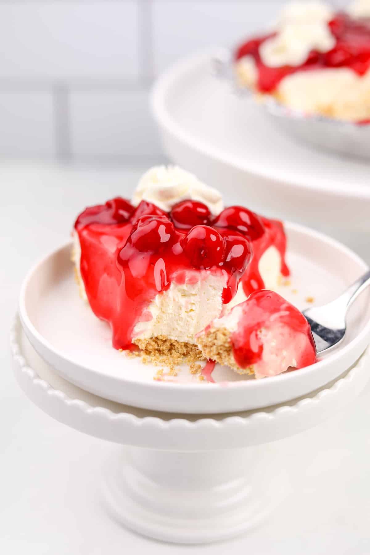 A slice of cherry no bake cheesecake with a fork on the side.