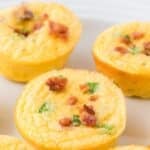 Round egg bites topped with crumbled bacon and green onion. The text reads: "Cottage cheese egg bites"