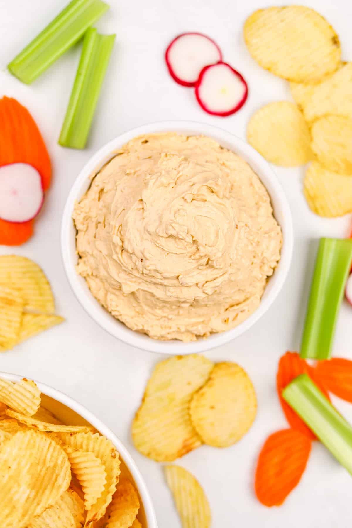 A bowl filled with onion soup dip, served with veggies or potato chips.