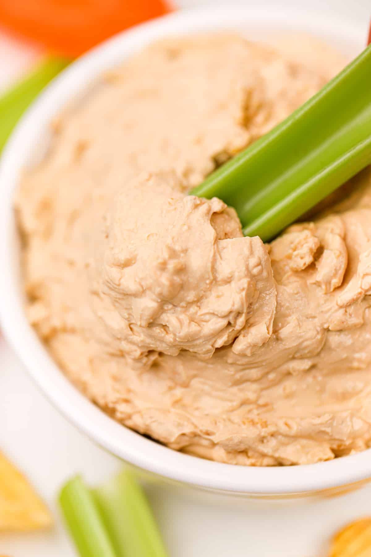 Dipping a celery stick into french onion dip.