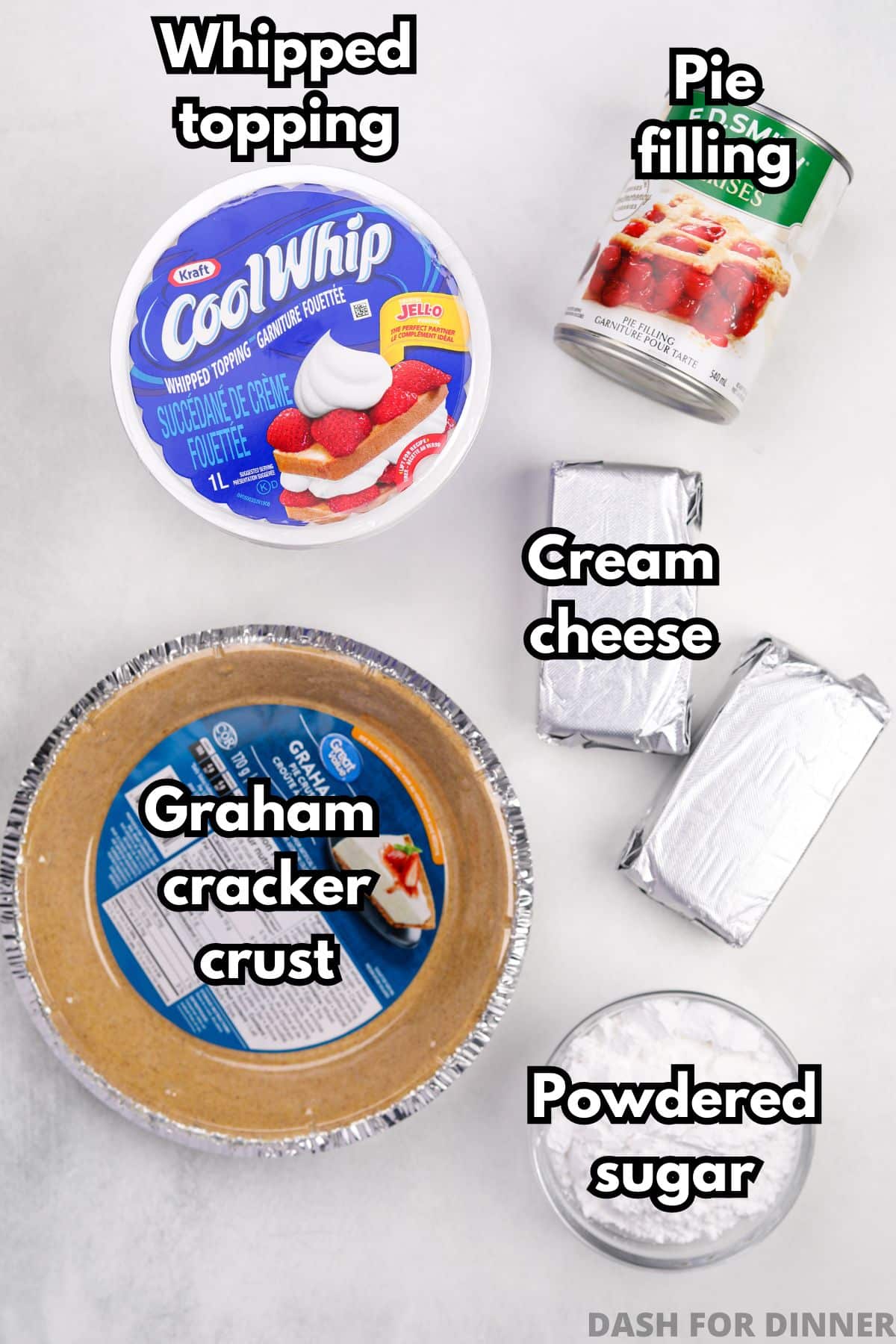 The ingredients needed to make no bake cheesecake: a premade graham cracker crust, cool whip, pie filling, cream cheese, and powdered sugar.