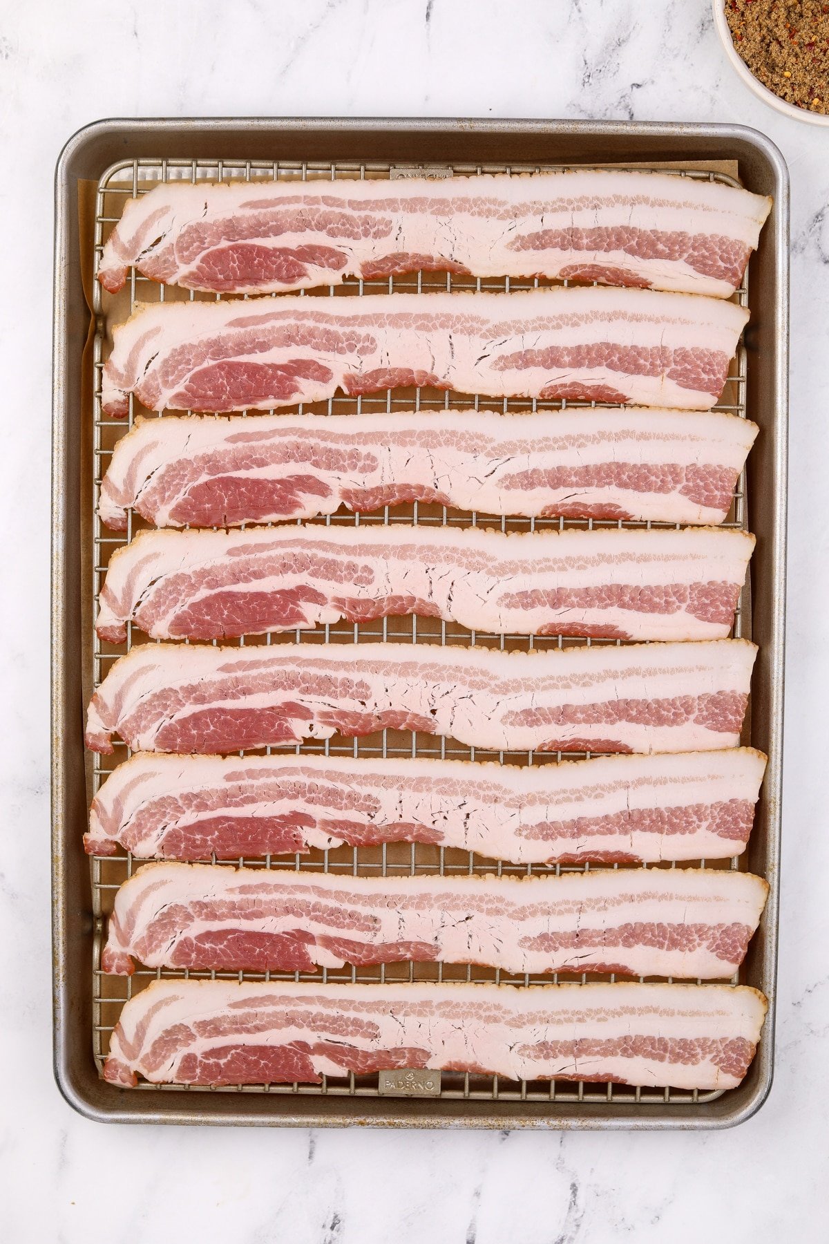 A baking sheet filled with bacon slices.