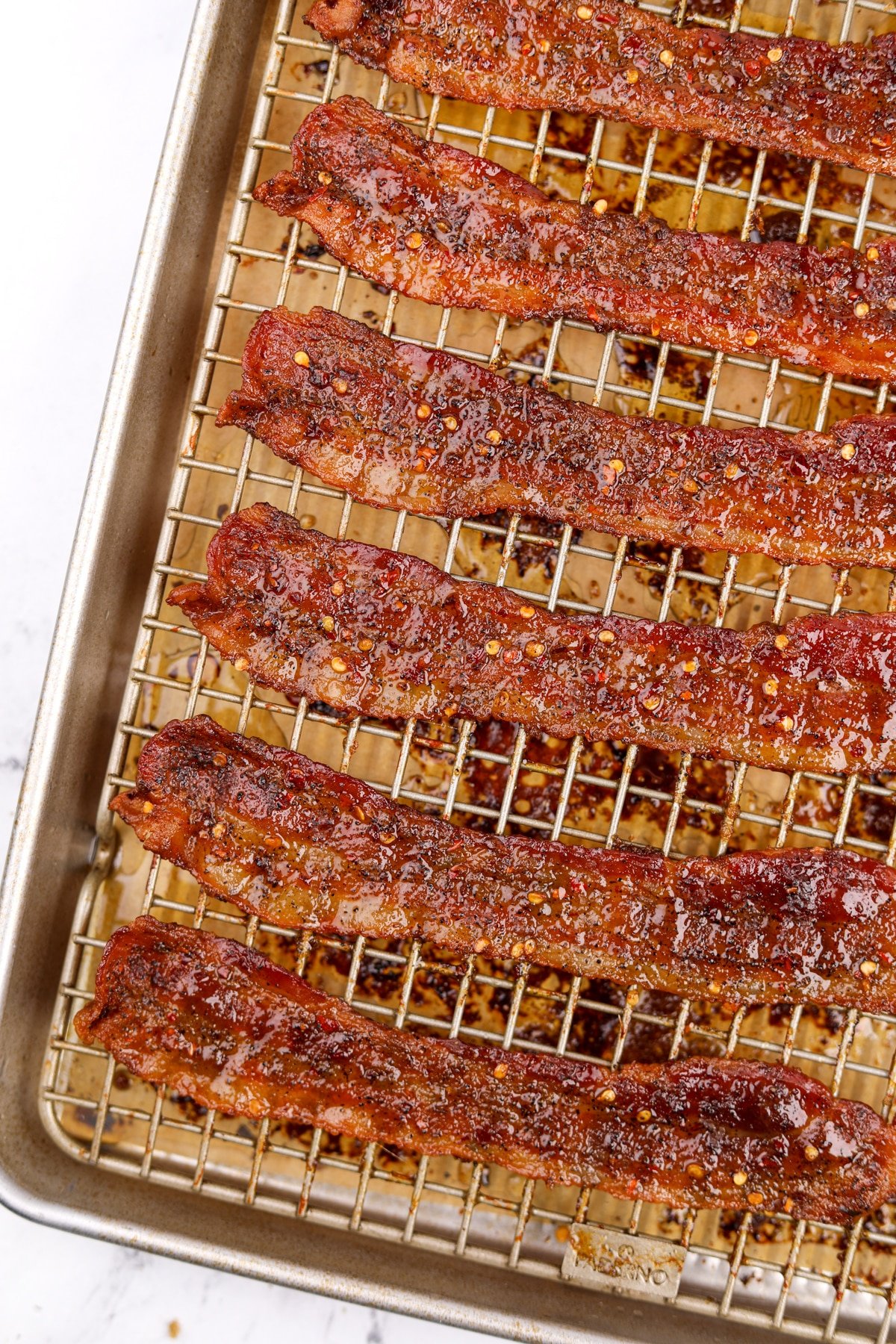 Crispy bacon on a wire rack that's been cooked with brown sugar and crushed chilies.