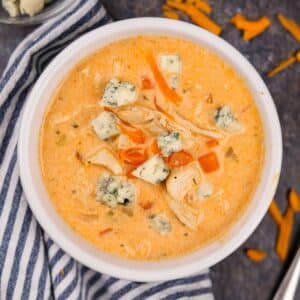 A bowl of buffalo chicken soup topped with blue cheese crumbles.