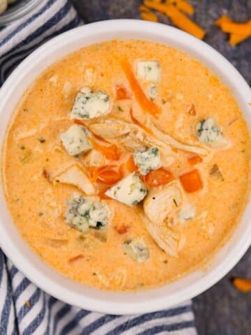 A bowl of buffalo chicken soup topped with blue cheese crumbles.
