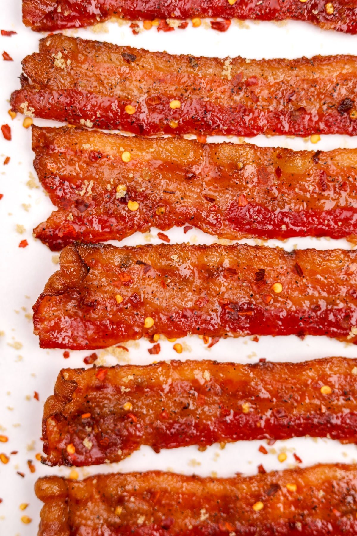 Slices of bacon that are coated with a sweet and spicy glaze.