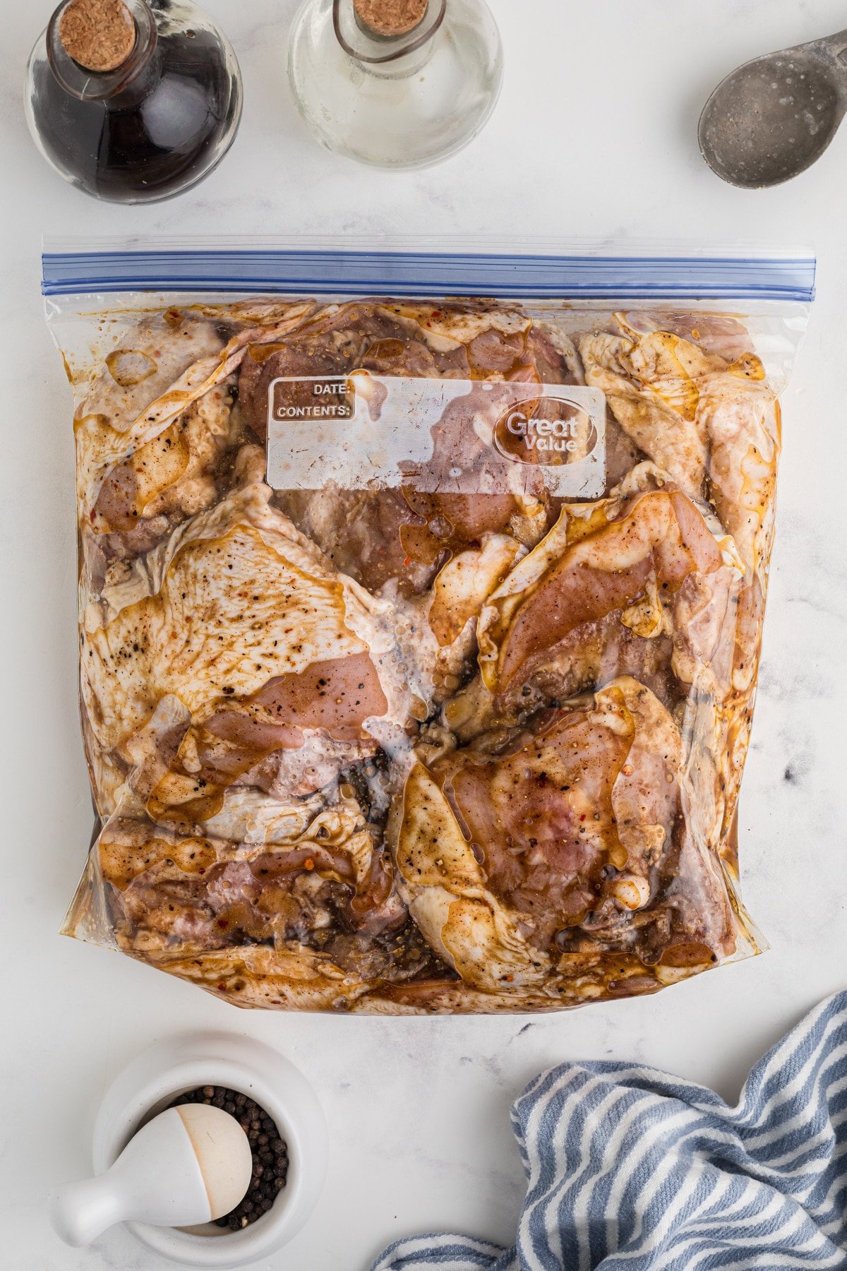 A freezer bag filled with chicken thighs that are marinating.