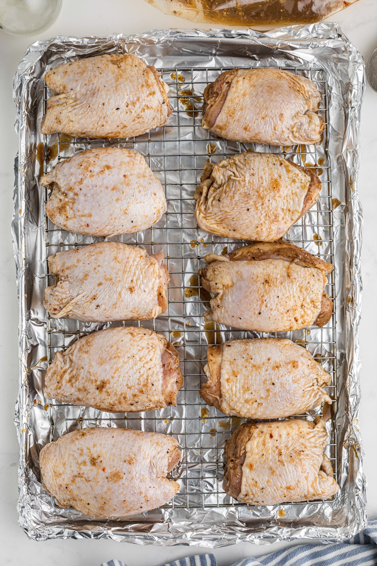 Chicken thighs on a wire baking rack.