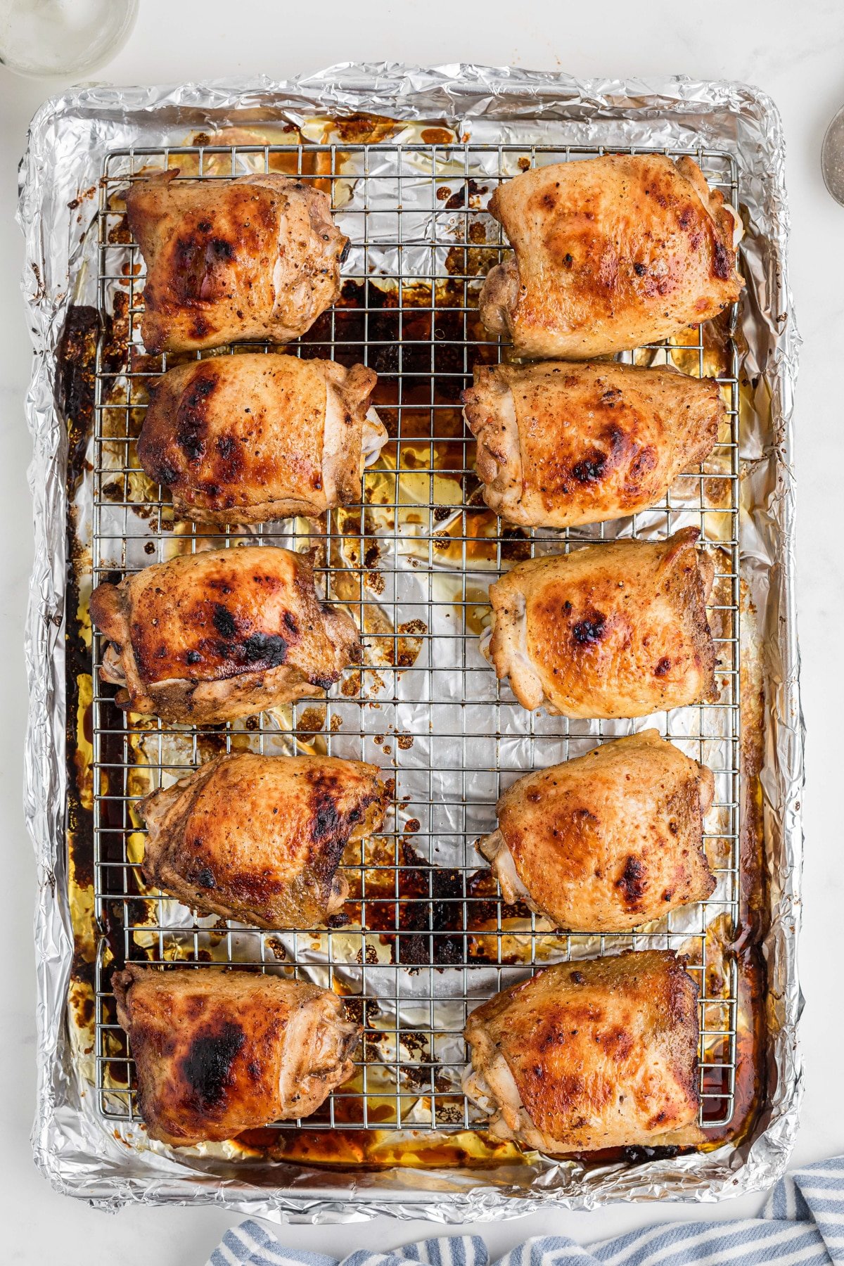 Baked chicken thighs on a wire baking rack.