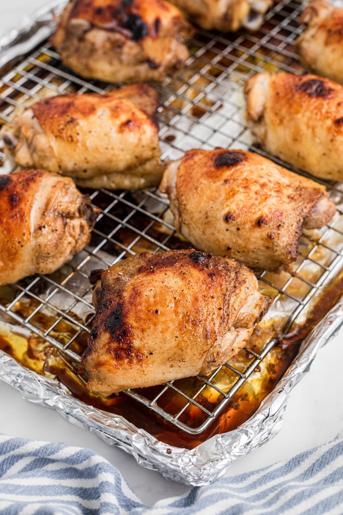 Baked chicken thighs on a wire baking rack.