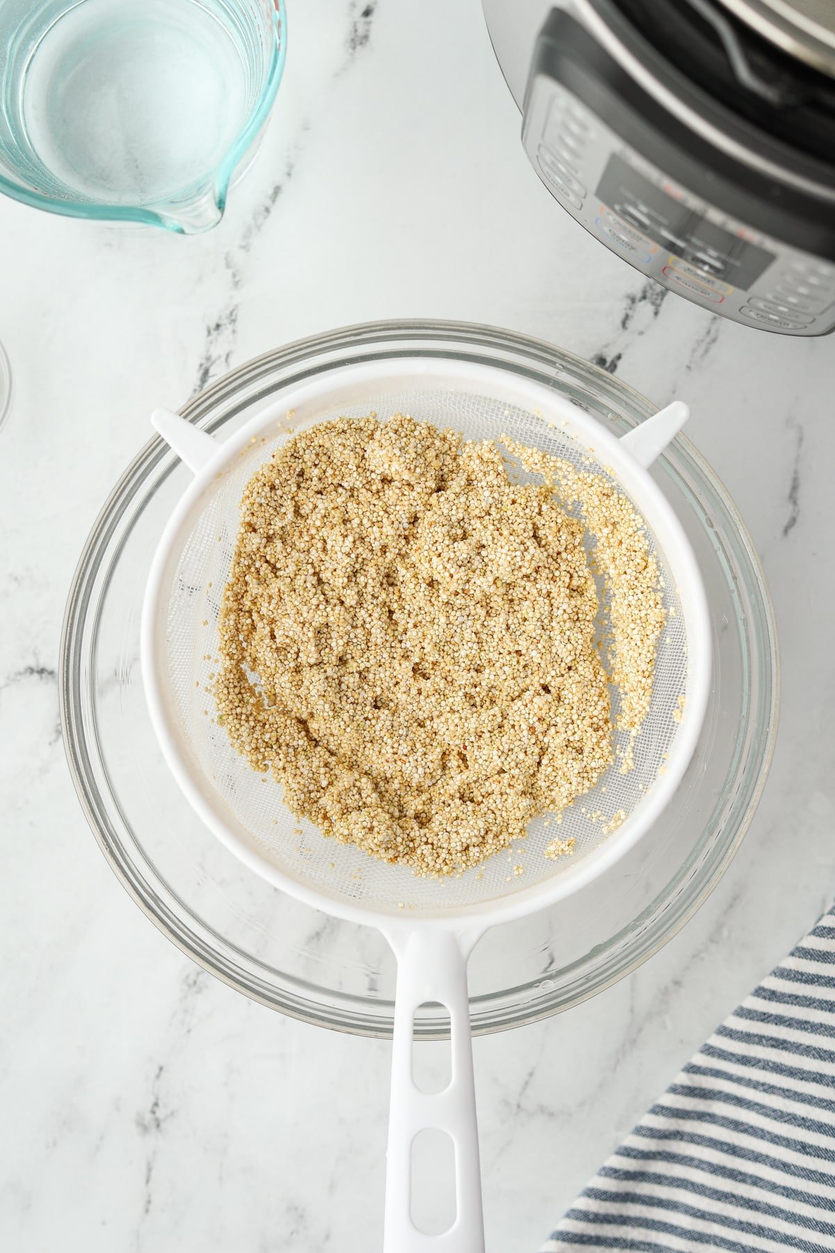 Quinoa that has been rinsed in a mesh strainer.