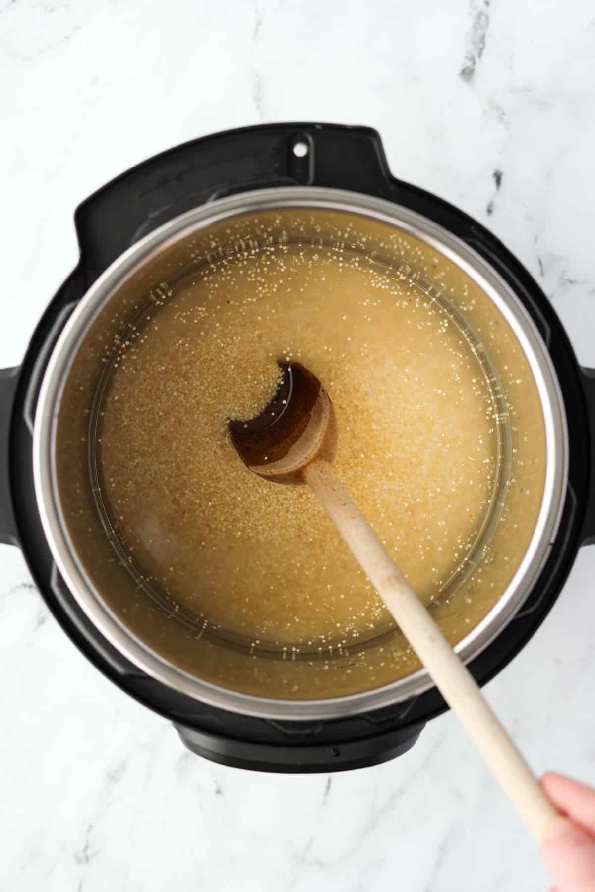 Stirring an Instant Pot with quinoa.