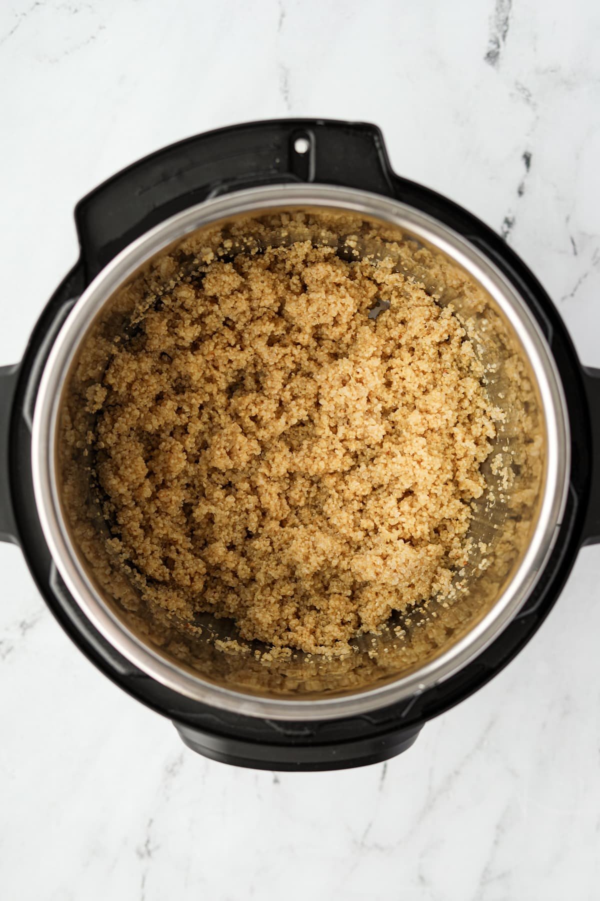 An Instant Pot filled with cooked quinoa.