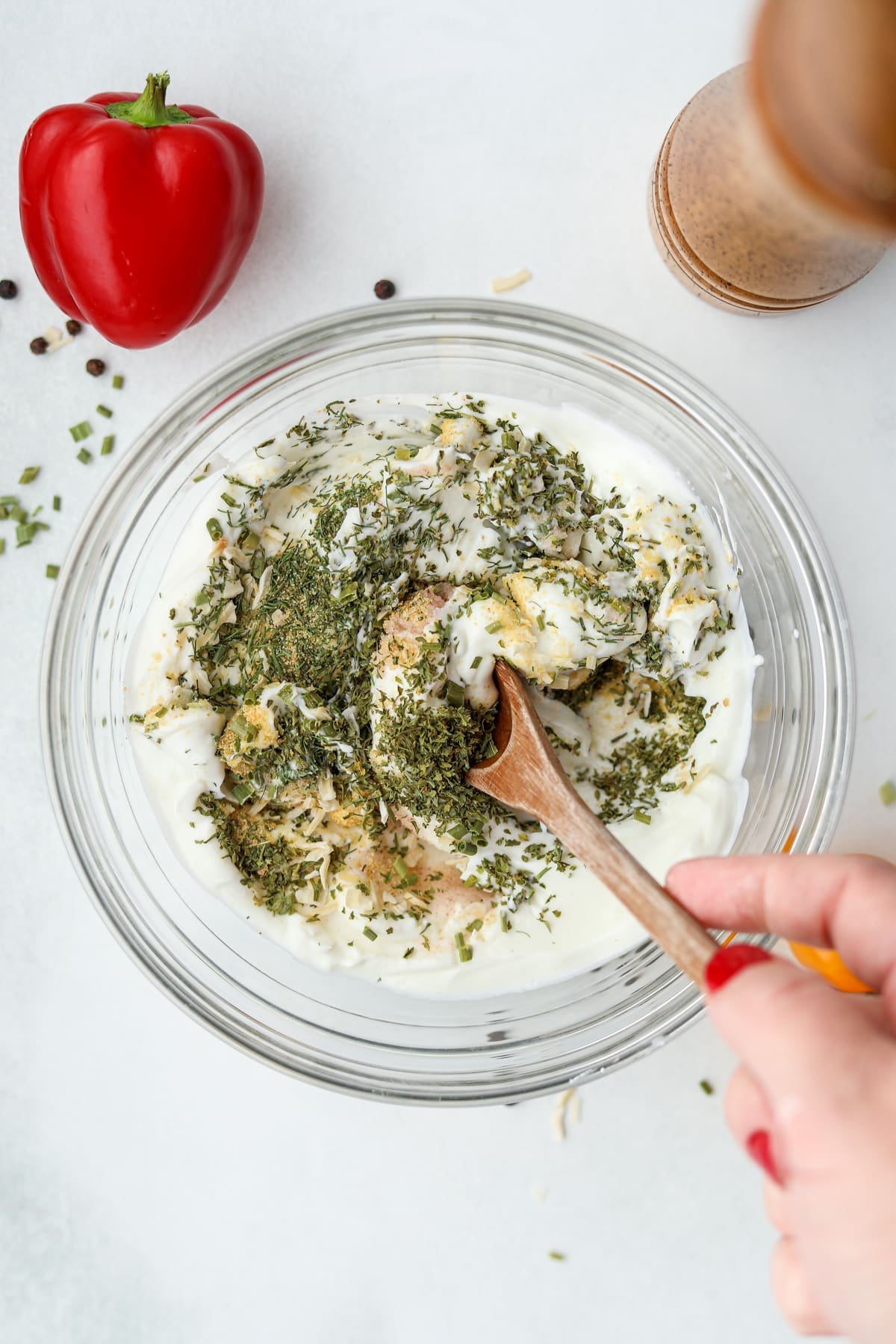 Stirring seasonings into a bowl of Greek yogurt.