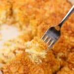 A fork holding a small amount of hash brown casserole.