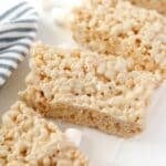 Homemade rice krispies treats on a white background with a blue stripe napkin.