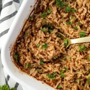 Scooping rice from a baking dish.