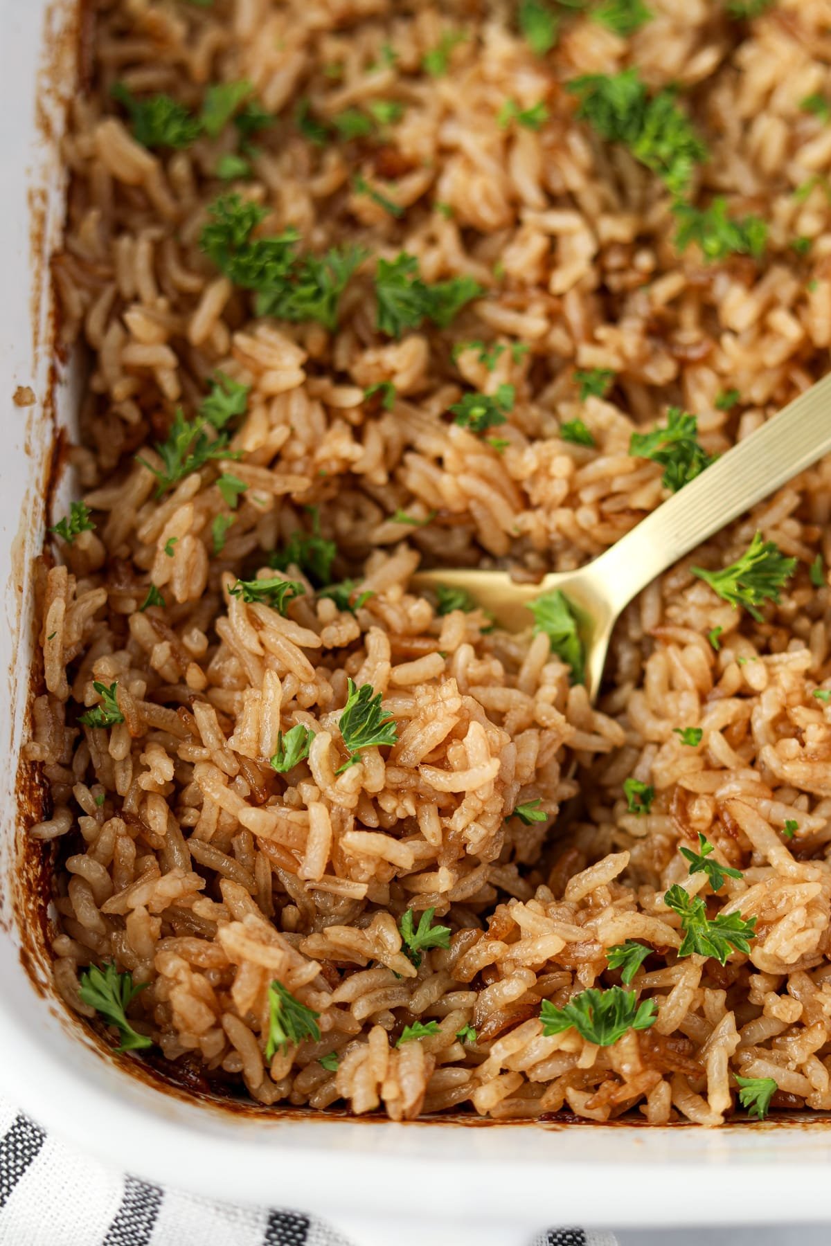 Scooping rice from a baking dish.